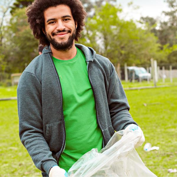 A man picks up trash in a park.